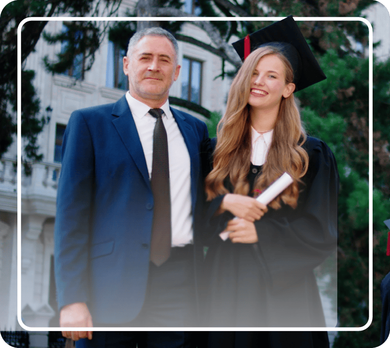 Young lady posing with her father at her graduation.