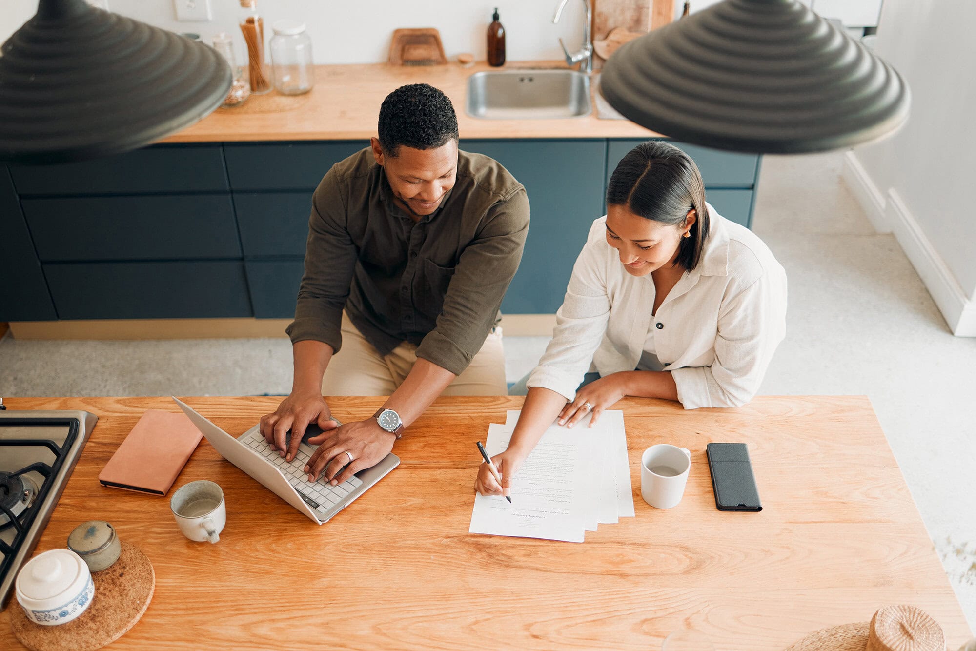 Couple reviewing different saving methods on paper and electronically.