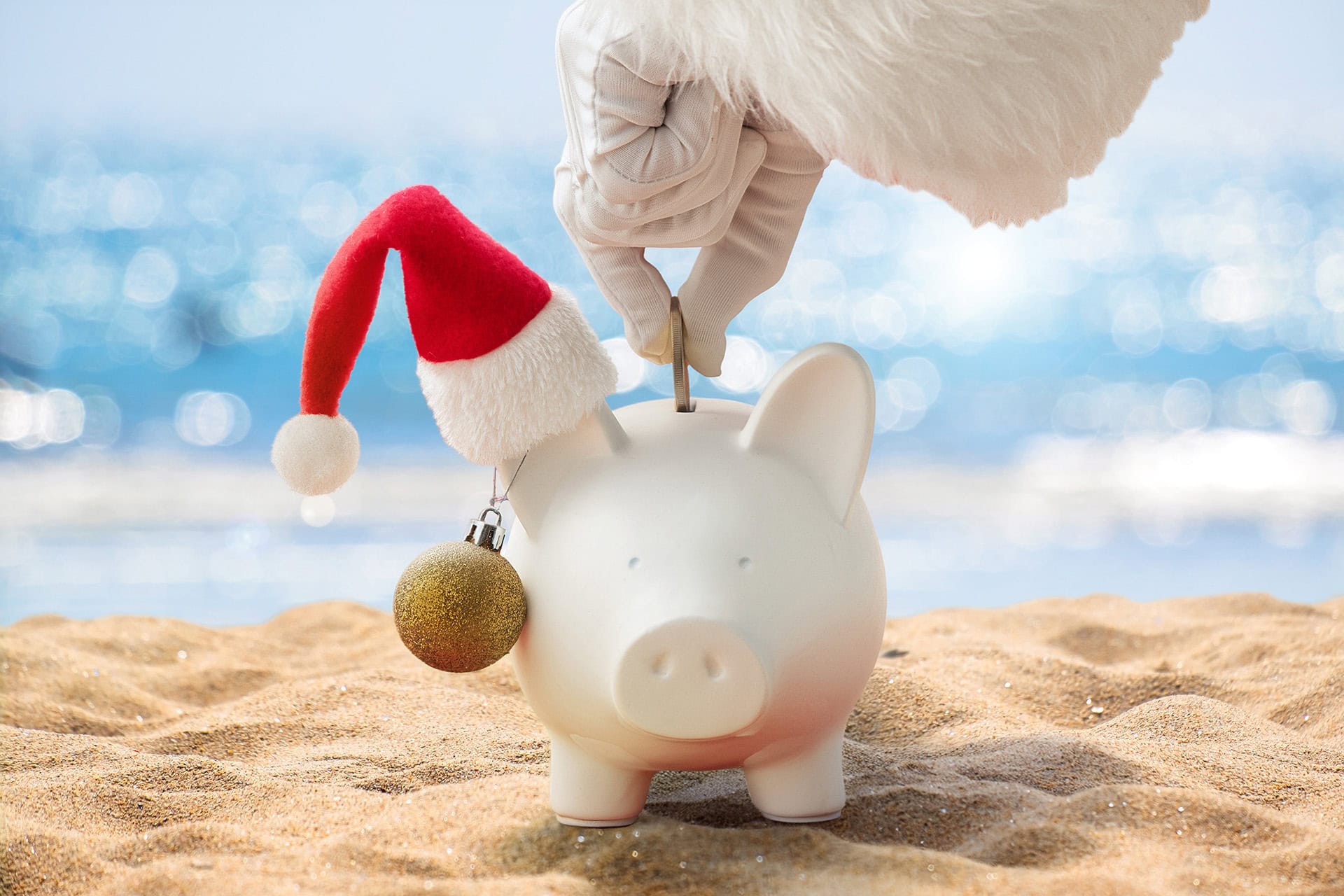 Santa putting coins into a piggy bank wearing a Santa hat on one ear