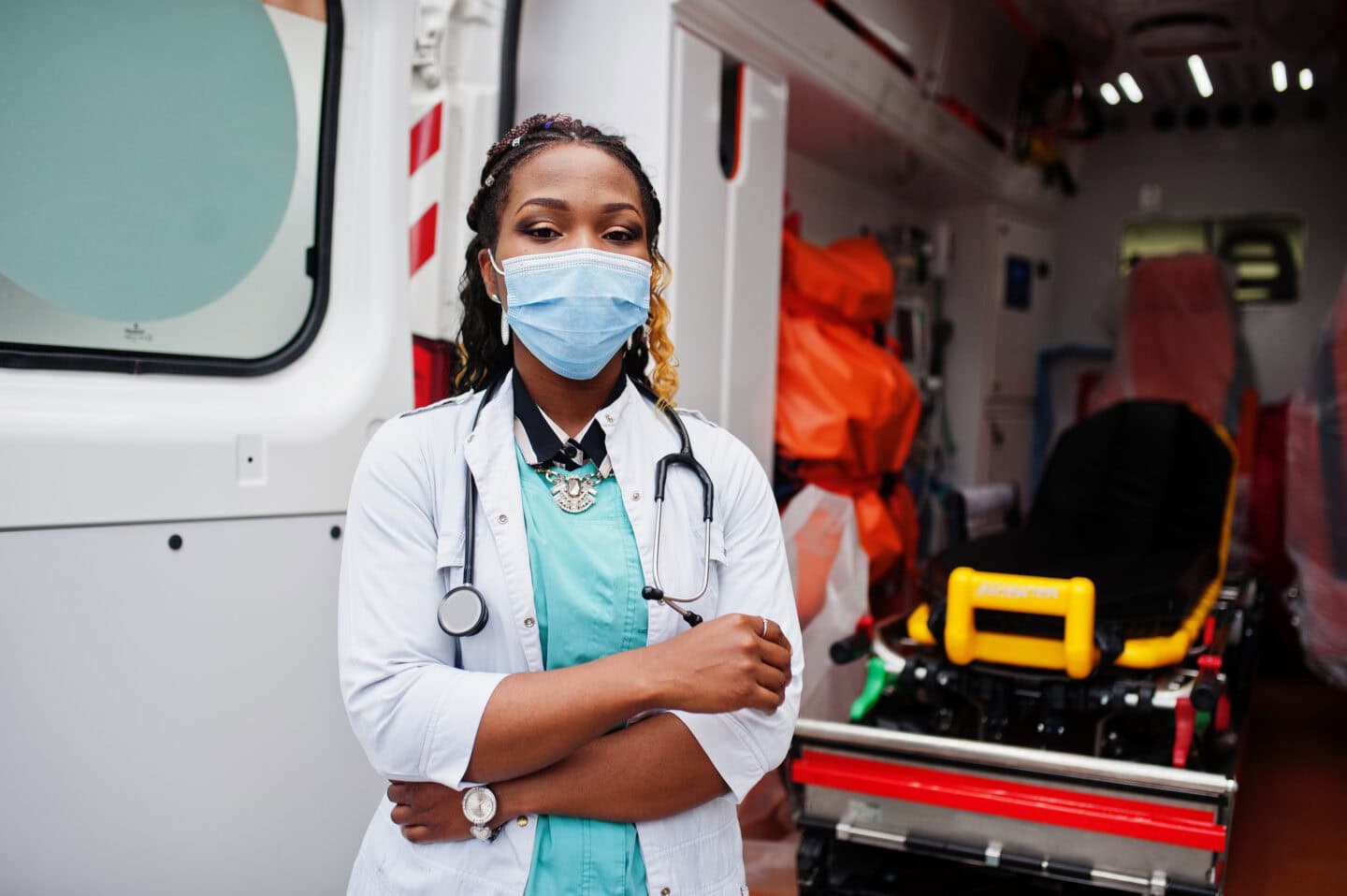 First responder standing in front of an open ambulance prepared to assist